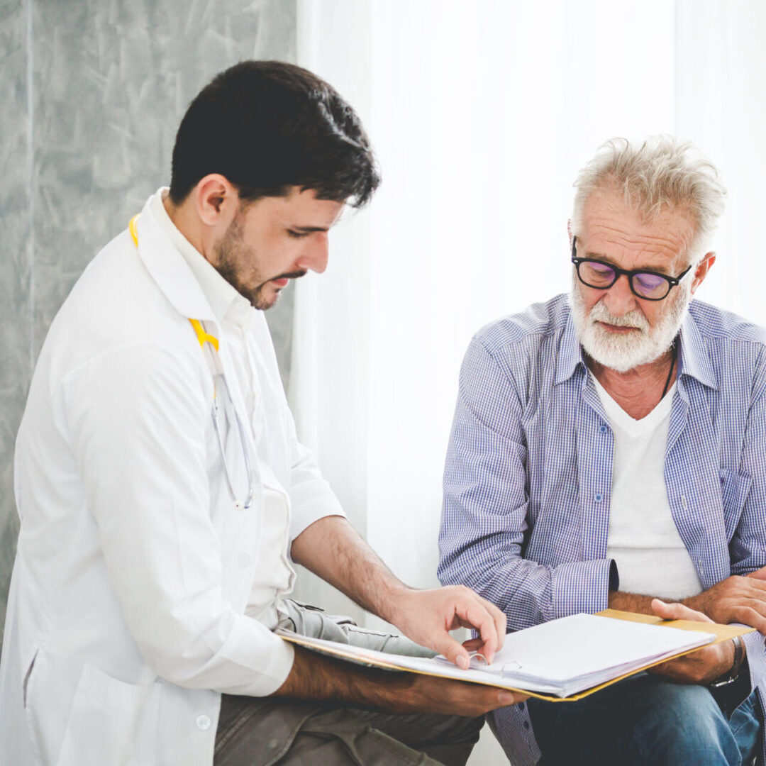 A doctor and an older man looking at papers.