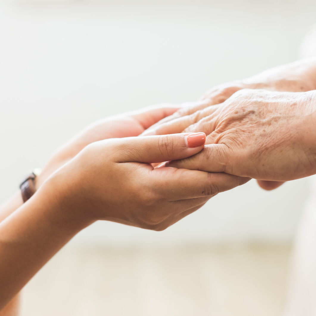 A person holding hands with an older person.