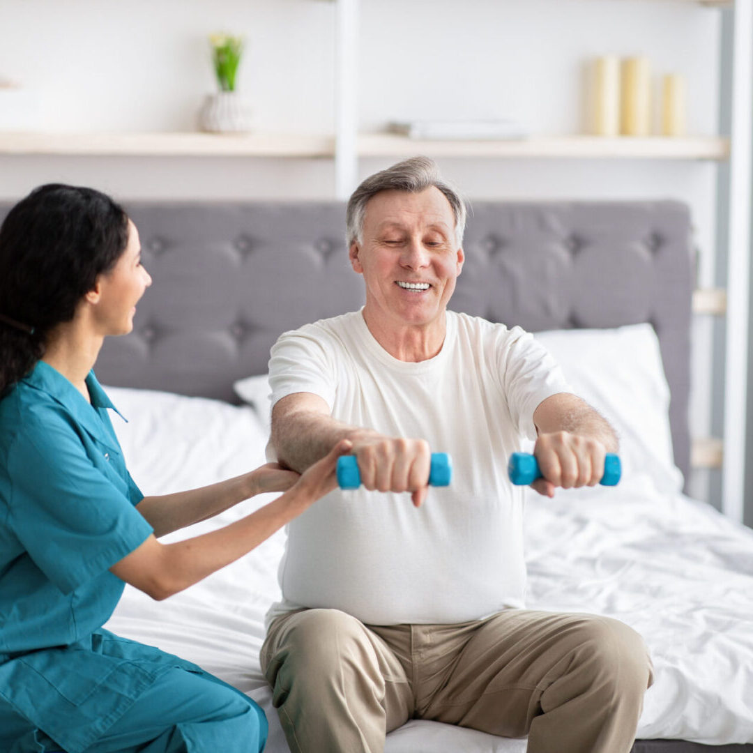 A woman helping an older man exercise with blue dumbbells.